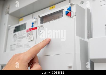 Man checking household electricity meter, close up Stock Photo