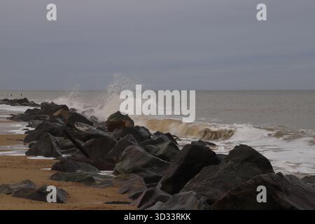 A view of waves breaking against rock armour sea defences in early winter on the North Norfolk coast at Happisburgh, Norfolk, England, United Kingdom. Stock Photo