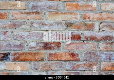 Close-up of a weathered brick wall, showcasing the texture and colors of the aged masonry Stock Photo