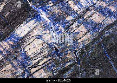Natural stone texture, KATUBA BLUE SODALITE granite slab, gray color with blue and milky additions and cracks Stock Photo