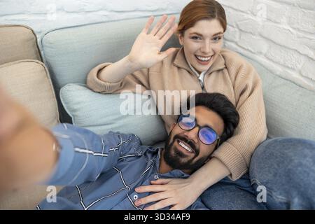 Smiling couple waving hands and looking happy Stock Photo