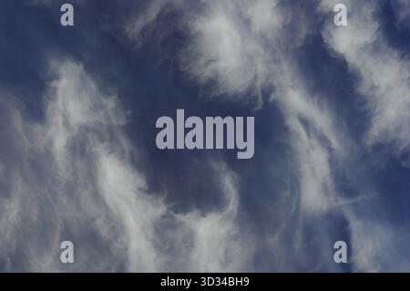 A beautiful view of wispy white clouds against a deep blue sky Stock Photo