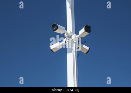Security video cameras on a pole on blue sky background Stock Photo