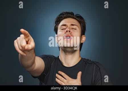 Young man pointing with finger and laughing Stock Photo