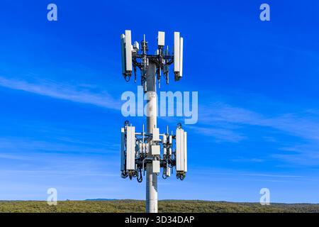 Drone aerial photograph of the top section of a large Cellular Tower against a bright blue sky background in the Blue Mountains, Australia. Stock Photo