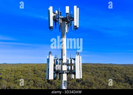 Drone aerial photograph of the top section of a large Cellular Tower against a bright blue sky background in the Blue Mountains, Australia. Stock Photo