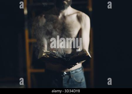 Man hold burning book in his hands Stock Photo