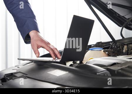 Services car engine machine concept, Automobile mechanic repairman checking a car engine with using computer diagnostics while repairing, car service Stock Photo