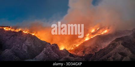 Flames from the Big Horn Fire tear across the steep slopes of the Santa Catalina Mountains above Tucson, Arizona Stock Photo