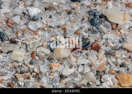 Close-up of beach sand grains collected from Ft. Lauderdale, Florida. The sample shows a diverse mix of mineral and biogenic particles. Stock Photo