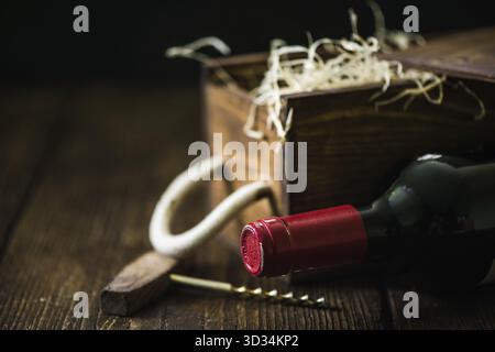 Red wine bottle and wooden crate in wine cellar Stock Photo