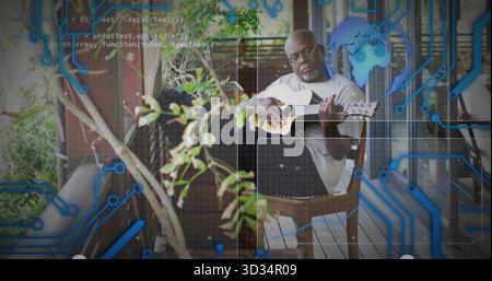 Strumming retired musician playing acoustic guitar on porch, with guitar case and circuit overlay Stock Photo