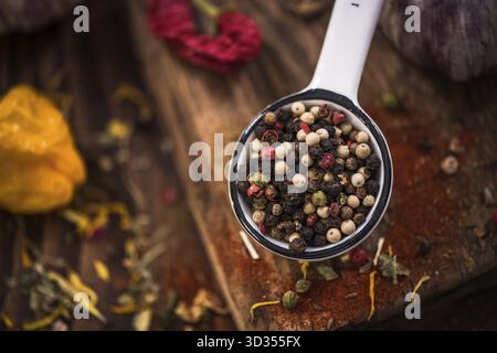 Whole pepper seeds on spoon Stock Photo