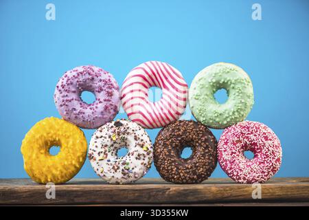 Colorful vibrant donuts pyramide against blue vibrant bacground Stock Photo
