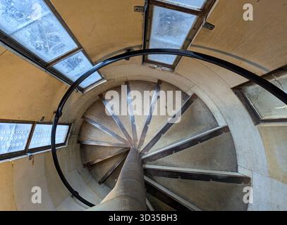 Interior of Cologne Cathedral tower featuring a spiral staircase, historic architecture, intricate stone details, natural light, and serene sacred atm Stock Photo