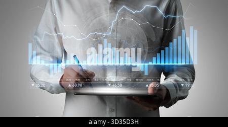 Business analyst engages with digital tablet while examining dynamic financial data presented through graphs and charts, illustrating market Stock Photo