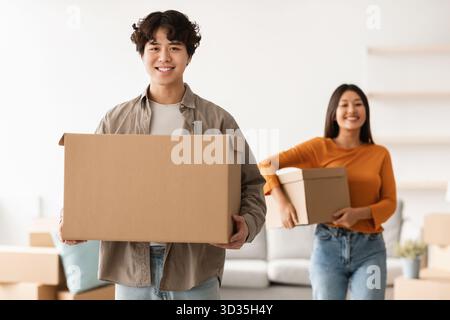 Young Couple Unpacking Boxes in Their New Home While Enjoying Their Move Together Stock Photo