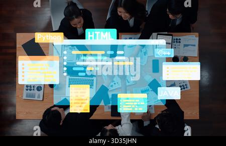 A group of professionals collaborates in an office setting, engaging with programming concepts and data visualization to enhance project outcomes and Stock Photo
