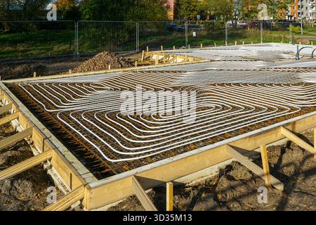 Underfloor heating installation with plastic pipes in concrete foundation at new house construction site Stock Photo