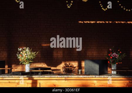 Stylish catering station with dark decor, citrus blooms and warm sunlight - ideal for luxury venue branding or wedding styling. Stock Photo