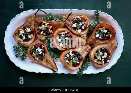 Baked pears with Feta cheese, walnuts, thyme and cranberries. Table top view from overhead. Stock Photo