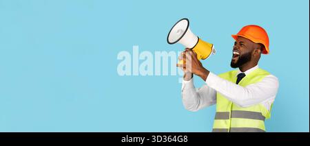 Emotional Black Builder Man Making Announcement With Loudspeaker Over Blue Background Stock Photo