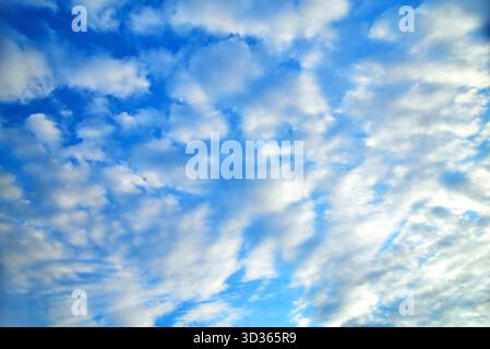 clouds of different shapes in the blue sky illuminated by the sun's rays close-up selective focus Stock Photo