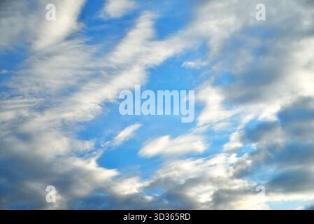 clouds of different shapes in the blue sky illuminated by the sun's rays close-up selective focus Stock Photo