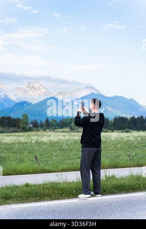 A tourist takes a photo of mountains, capturing a magical moment in the Austrian mountains. Stock Photo