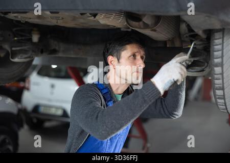 Service station man employee works in repair box, department Stock Photo