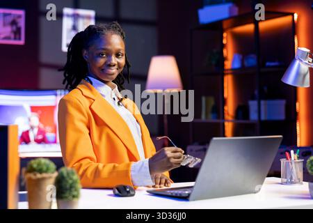 Portrait of upbeat teleworker using laptop in home office to write emails. Joyous remote worker typing on notebook, composing documents in order to deliver finalized project paperwork Stock Photo