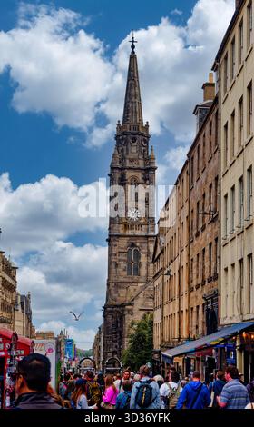 EDINBURGH, SCOTLAND - Aug 22, 2024: Crowds fill the Royal Mile beneath the towering steeple of the Tron Kirk, a historic church now central to the cit Stock Photo