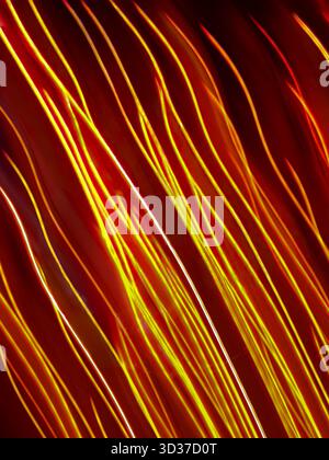 Colorful glow sparks streams of light texture. Orange red rays on dark background .Flare abstract effect. Stock Photo