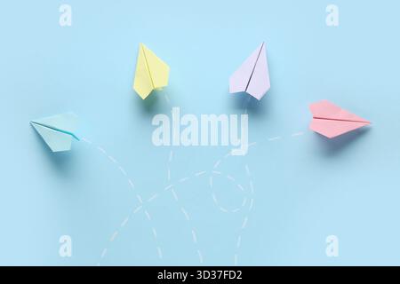 Colorful paper planes with dotted lines on blue background Stock Photo
