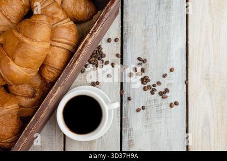 Coffee cup with croissant on a rustic wooden table. Food. tasty fresh croissants. Continental breakfast served with freshly baked pastry. Good morning Stock Photo