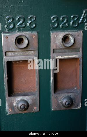 Old vintage dmetal oorbell and peephole on green metal door Stock Photo