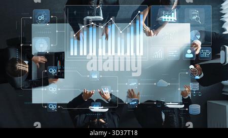 A dynamic business team collaborates in a modern office, analyzing data trends and reports with digital interfaces and graphs overlaying the scene Stock Photo