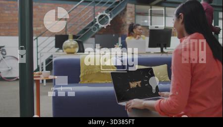 Showing office professional holding NFT laptop on blue sofa in open-plan office lounge, copy space Stock Photo