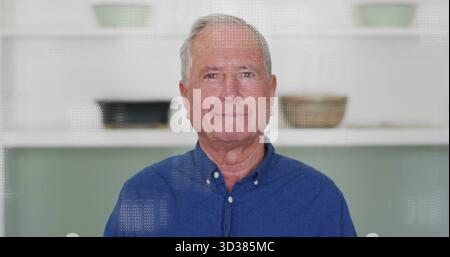 Standing senior man wearing blue button-down shirt smiling at camera at home with shelves and bowls Stock Photo