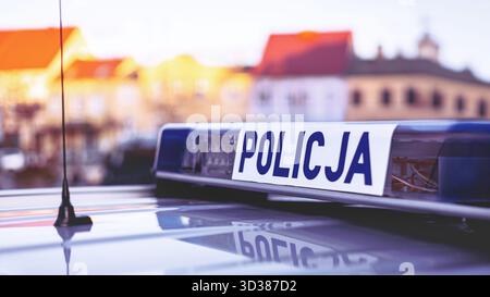 Polish police ("Policja") blue lights panel on top of a patrol car, with blurred buildings in the background. Stock Photo