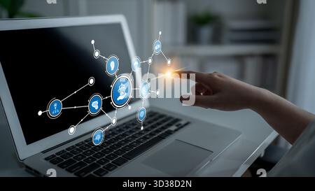 A hand interacts with a laptop screen displaying digital icons, symbolizing technology and innovative ideas in a modern workspace, emphasizing Stock Photo