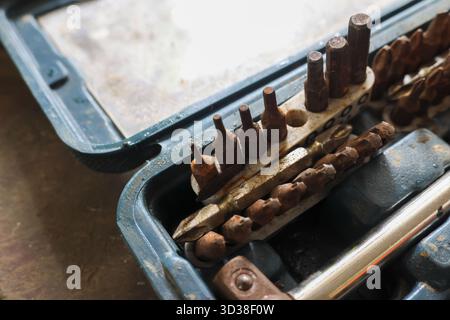 Old rusty tool set with drill and screwdriver bit in dirty blue toolbox. neglected collection of corroded metal equipment in workshop for repair and m Stock Photo
