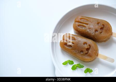 Homemade apple lemon mint popsicles isolated on a white plate Stock Photo