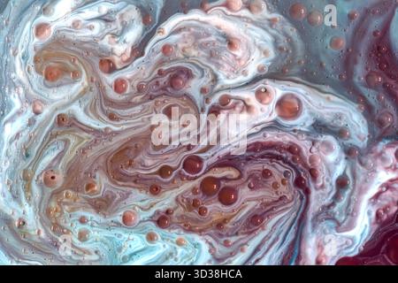 Abstract macro of colorful liquids mixing. Swirls of red, blue, and white create cosmic texture, fluid motion and organic shapes. Stock Photo