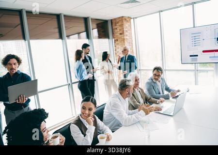 Professionally coordinated business gathering with diverse team members collaborating on a strategic project at a modern corporate office Stock Photo