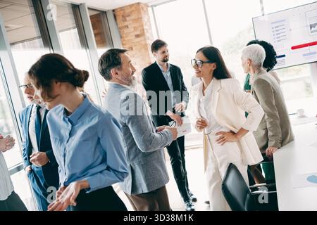 Group of diverse professionals networking and collaborating during a business meeting in a modern office environment Stock Photo