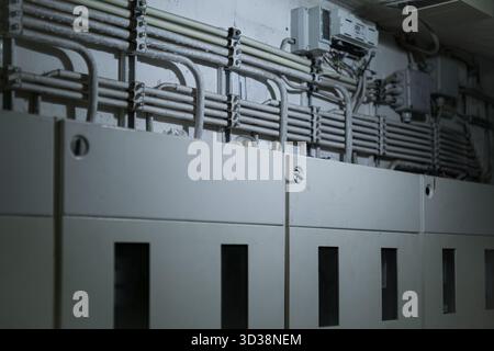 Electric meters and organized cable conduits in utility room representing energy distribution system. Stock Photo