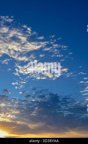 Vivid blue sky with scattered white clouds floating gracefully, capturing the freshness and purity of daylight atmosphere. Stock Photo