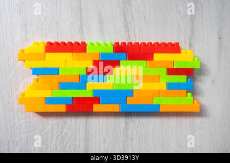 Assembled multi-colored plastic construction blocks lie on the floor. Stock Photo