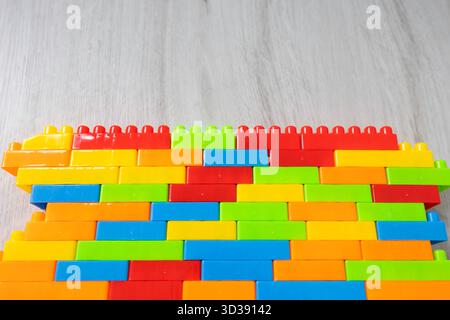Assembled multi-colored plastic construction blocks lie on the floor. Stock Photo